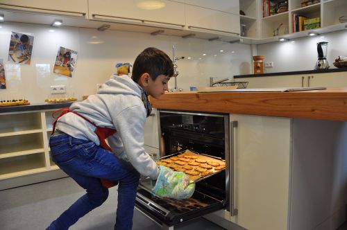 Die Brotchips sind fertig, Hishya holt sie aus dem Ofen