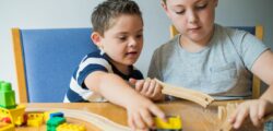 Geschwister von kranken Kindern stärken: Zwei Brüder spielen mit Holzeisenbahn