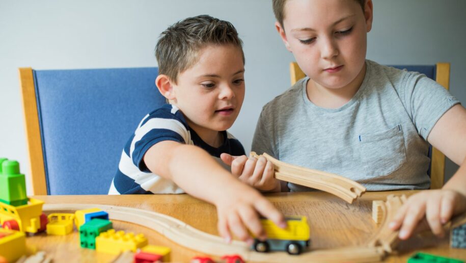 Geschwister von kranken Kindern stärken: Zwei Brüder spielen mit Holzeisenbahn